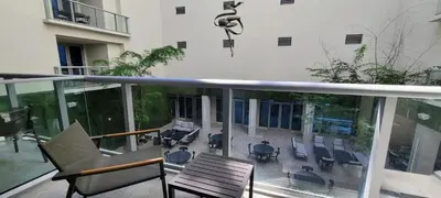 an apartment balcony with chairs and a table and chairs at CH Luxury Condos & Studios On The Beach in Hollywood