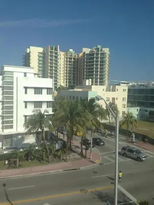 a city with a street with palm trees and buildings at Collins Avenue Hostel in Miami Beach