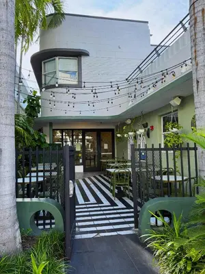 a building with a patio with tables and chairs at The Cove By Renzzi in Miami Beach