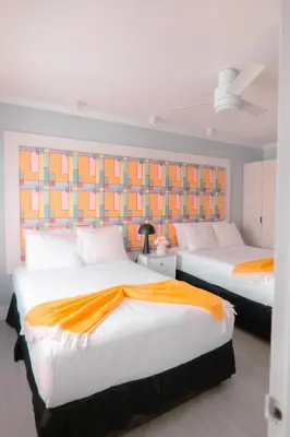 two beds in a room with orange and white at The Cove By Renzzi in Miami Beach