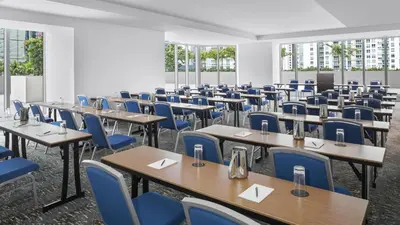 an empty room with tables and blue chairs at Hyatt Centric Brickell Miami in Miami