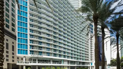 a large building with a palm tree in front of it at Hyatt Centric Brickell Miami in Miami