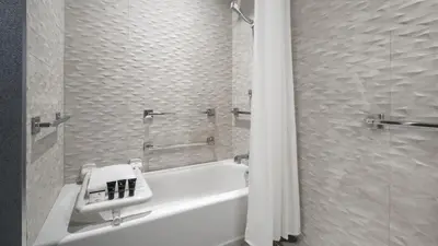a bathroom with a white tub and a sink and a shower at Hyatt Centric Brickell Miami in Miami