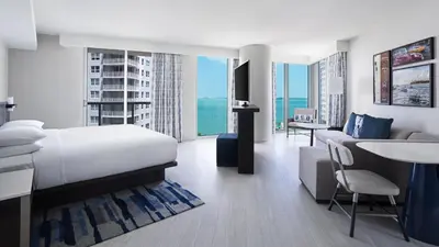 a hotel room with a bed and a living room at Hyatt Centric Brickell Miami in Miami