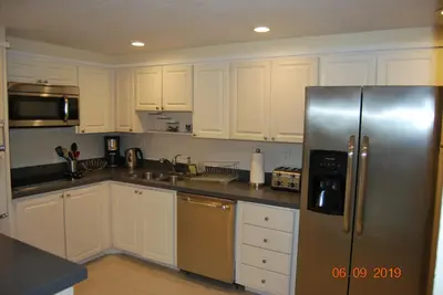 a kitchen with white cabinets and a stainless steel refrigerator at Ocean Reserve Piso 7 STR-310 in Miami Beach