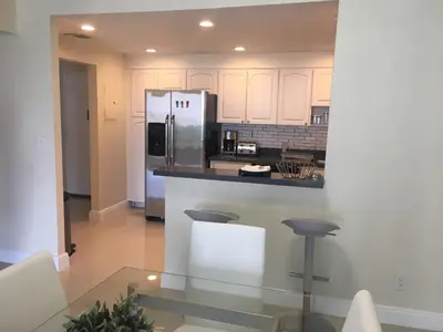 a kitchen with white cabinets and a stainless steel refrigerator at Ocean Reserve Piso 4 STR264 in Miami Beach