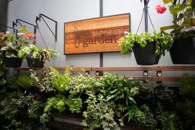 a garden sign on a wall with potted plants at JW Marriott Marquis Miami in Miami
