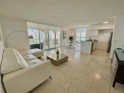 a living room with a white couch and a table at The King David Condos in Miami Beach