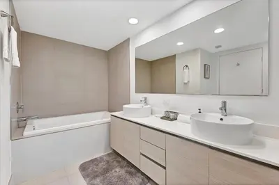 a bathroom with two sinks and a tub and a mirror at Three-Bedroom Beachwalk Resort Apartment in Hallandale Beach