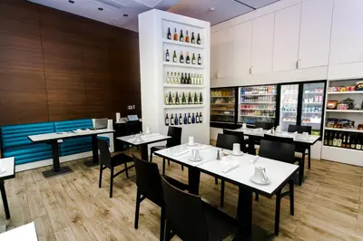 a restaurant with tables and chairs and wine bottles at Three-Bedroom Beachwalk Resort Apartment in Hallandale Beach