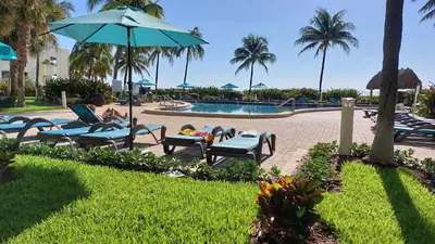 a group of chairs and an umbrella next to a pool at THE TIDES 2 bedrooms 9th floor WE ARE ON THE BEACH! in Hollywood
