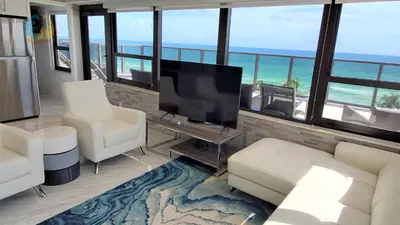 a living room with white furniture and a flat screen tv at Luxury Beach Resort - HORA RENTALS in Miami Beach