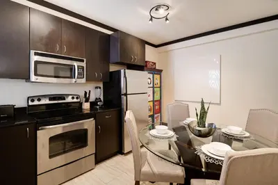 a kitchen with a dining table and a kitchen with a microwave at Tradewinds Apartment Hotel Miami Beach in Miami Beach