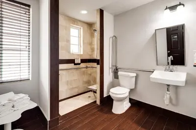 a bathroom with a toilet and a sink and a shower at Tradewinds Apartment Hotel Miami Beach in Miami Beach