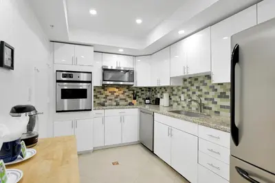 a kitchen with white cabinets and stainless steel appliances at 2 BEDROOMS 2 FULL BATHROOMS APT. ON THE BEACH in Hollywood