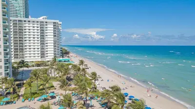 an aerial view of a beach with palm trees and buildings at 2 BEDROOMS 2 FULL BATHROOMS APT. ON THE BEACH in Hollywood
