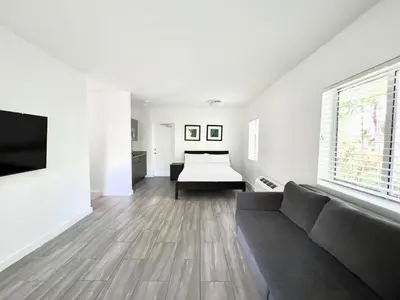 a living room with a couch and a bed at Beach Gardens in Fort Lauderdale