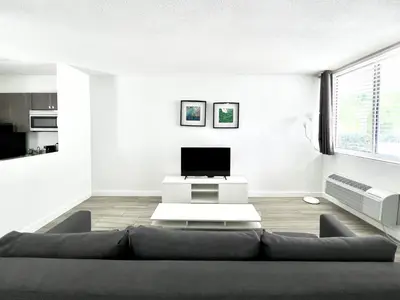 a living room with a couch and a tv at Beach Gardens in Fort Lauderdale
