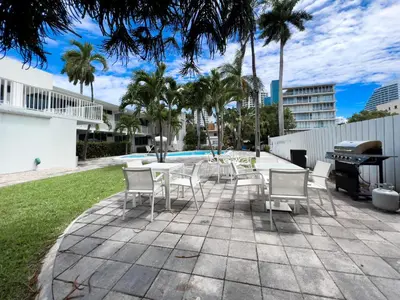 a patio with a table and chairs and a grill at Beach Gardens in Fort Lauderdale