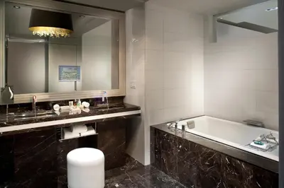 a bathroom with a tub and a large mirror at Hotel Beaux Arts, Autograph Collection in Miami