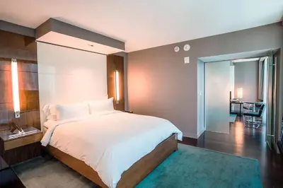 a bedroom with a large white bed and a hallway at Hotel Beaux Arts, Autograph Collection in Miami