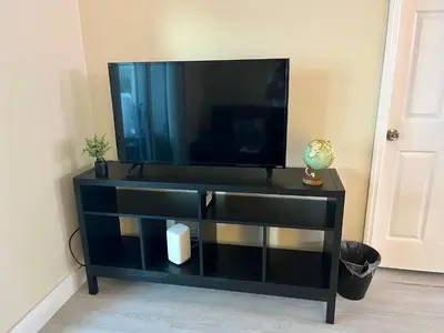 a black entertainment center with a flat screen tv at King condo Fort Lauderdale Central beach in Fort Lauderdale