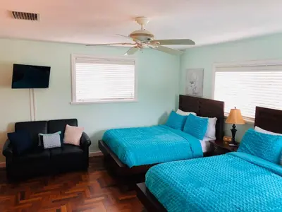 a bedroom with two beds and a couch and a ceiling fan at Blue House Miami in Miami Beach