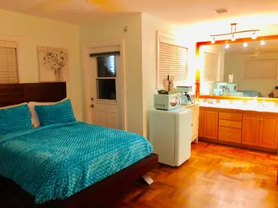 a bedroom with a bed and a bathroom with a sink at Blue House Miami in Miami Beach