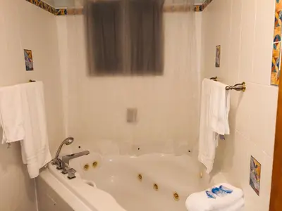 a white bathroom with a tub and a sink at Blue House Miami in Miami Beach