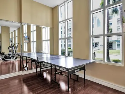 a ping pong table in a room with windows at King David Condominium Sunny Isles Beach in Miami Beach