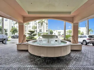 a large fountain in a building with people sitting around it at King David Condominium Sunny Isles Beach in Miami Beach