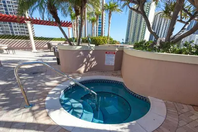 a small swimming pool with palm trees and buildings at King David Condominium Sunny Isles Beach in Miami Beach