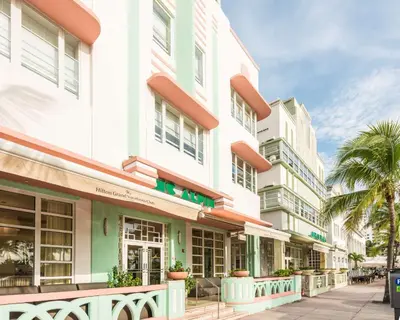 a row of buildings on a street with palm trees at Hilton Grand Vacations Club Mcalpin Ocean Plaza Miami in Miami Beach