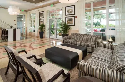 a lobby with leather couches and tables and windows at Hilton Grand Vacations Club Mcalpin Ocean Plaza Miami in Miami Beach