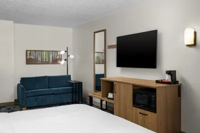 a hotel room with a bed and a tv and a chair at Hampton Inn Miami-Airport West in Miami