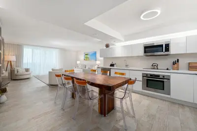 a kitchen with a wooden table and some chairs at Oceanview Private Condo at 1 Hotel & Homes -1122 in Miami Beach