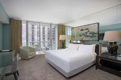 a bedroom with a large white bed and a desk at W Miami in Miami