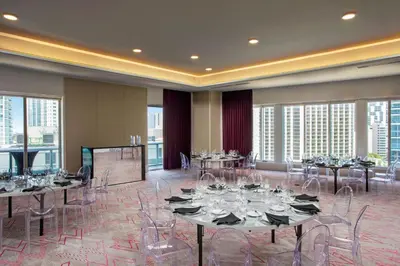 a conference room with tables and chairs and windows at W Miami in Miami