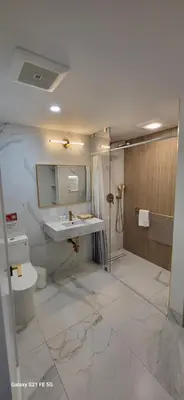 a bathroom with a shower and a sink and a toilet at Green Island Inn in Fort Lauderdale