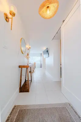 a hallway with a table and a mirror at Green Island Inn in Fort Lauderdale