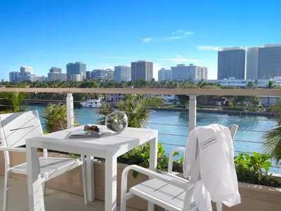 a white table and chairs on a balcony with a view at Grand Beach Hotel Bay Harbor in Miami Beach