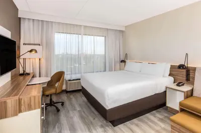 a hotel room with a bed and a desk and a television at Wyndham Garden Ft Lauderdale Airport & Cruise Port in Dania Beach