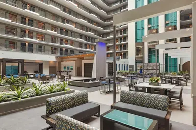 an open lobby of a building with tables and chairs at Embassy Suites by Hilton Miami International Airport in Miami
