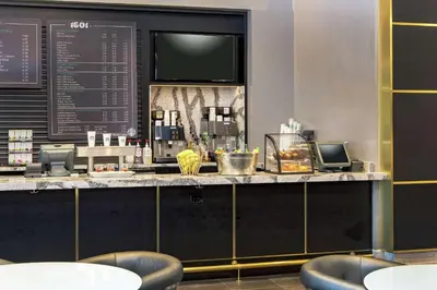 a bar in a restaurant with a counter with stools at Hilton Miami Downtown in Miami