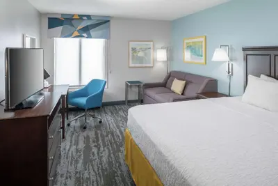 a hotel room with a bed and a desk and a television at Hampton Inn & Suites Miami-Doral Dolphin Mall in Miami
