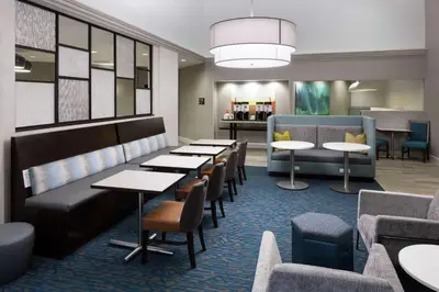 a waiting room with tables and chairs in a hotel at Hampton Inn & Suites Miami-Doral Dolphin Mall in Miami