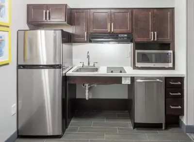 a kitchen with wooden cabinets and a stainless steel refrigerator at Hampton Inn & Suites Miami-Doral Dolphin Mall in Miami