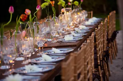 a long table with glasses and plates and flowers at Kimpton Surfcomber Hotel by IHG in Miami Beach