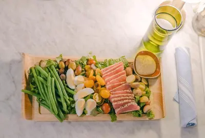a plate of food with meat and vegetables on a table at Kimpton Surfcomber Hotel by IHG in Miami Beach