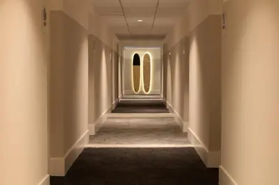 a hallway in a building with two windows at Kimpton Surfcomber Hotel by IHG in Miami Beach